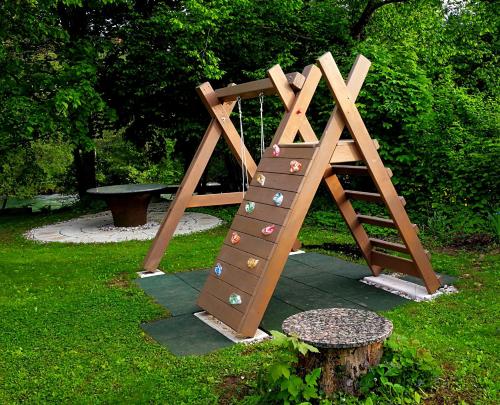 un parque infantil con una escalera de madera y un tronco de árbol en River house HRIB, en Preddvor