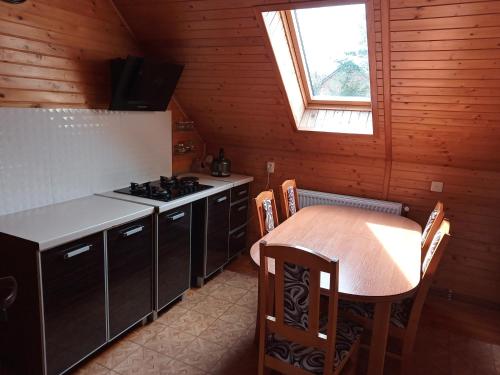 a kitchen with a table and a stove in a room at Agroturystyka Osada Leśna in Piecki
