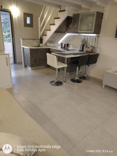 a kitchen with a table and chairs in a room at Irida Holiday Apartments in Stoupa
