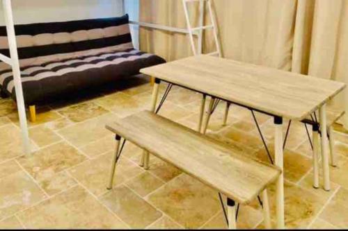 uma mesa de madeira e um banco numa sala de estar em studio centre de Hyeres ( 4 personnes ) em Hyères