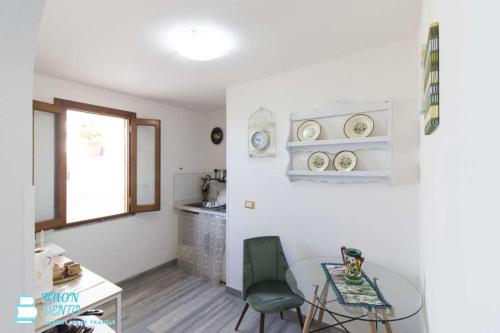 a dining room with a glass table and a kitchen at La Marea in Castro di Lecce