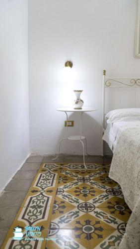 a bedroom with a bed and a table and a rug at La Marea in Castro di Lecce