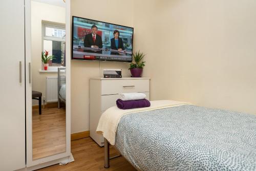 1 dormitorio con 1 cama y TV de pantalla plana en Single Room G1 (Sandycroft Guest House) en Londres