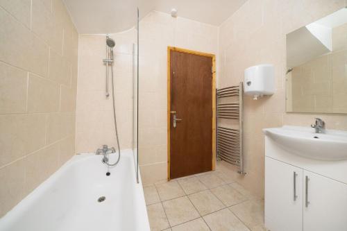 y baño con bañera, lavamanos y ducha. en Single Room G1 (Sandycroft Guest House) en Londres