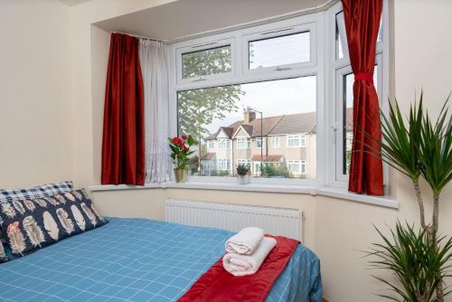 1 dormitorio con 1 cama y una ventana con cortinas rojas en Economy Double Room G2 (Sandycroft Guest House) en Londres