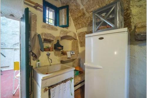 a kitchen with a sink and a refrigerator at Moundros 1620 Venetian Residence in Moúndros