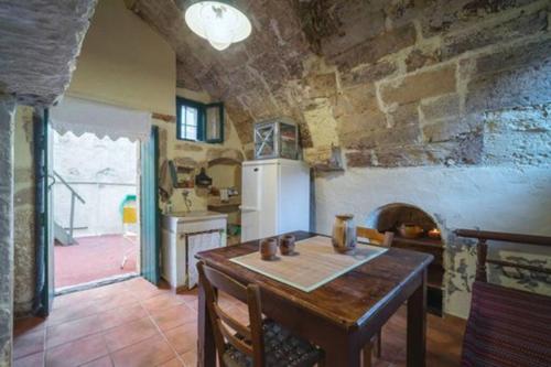 a kitchen with a table and a stone wall at Moundros 1620 Venetian Residence in Moúndros
