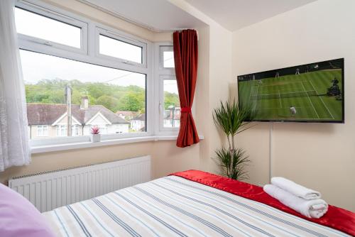 a bedroom with a flat screen tv and a bed at F4 Modern Double Room (Sandycroft Guest House) in London