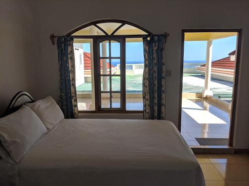 a bedroom with a bed and a view of the ocean at Barhanna Vista Lodge in Port Antonio