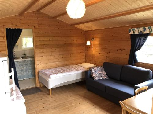 een slaapkamer met een bed en een bank in een kamer bij Stuga utanför Fjällbacka in Fjällbacka