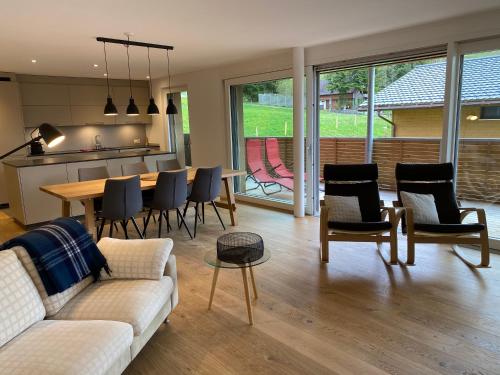 uma sala de estar com um sofá, uma mesa e cadeiras em Horizon 5 em Schwarzsee