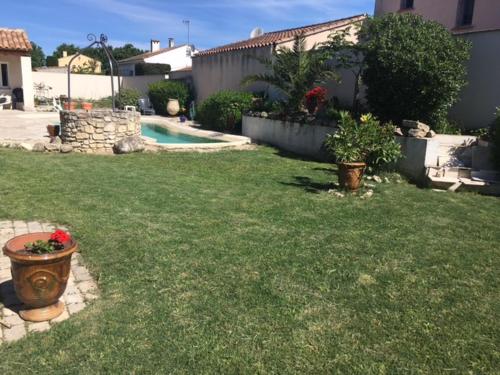 a yard with a pool and some plants in a yard at Coquet 2 pièces au calme avec piscine (2/4 pers) in Fontvieille