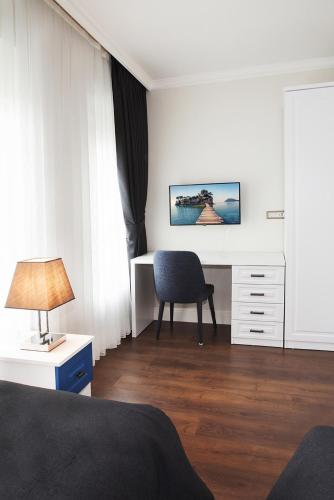 a white bedroom with a desk and a chair at Garlon Residence in Istanbul