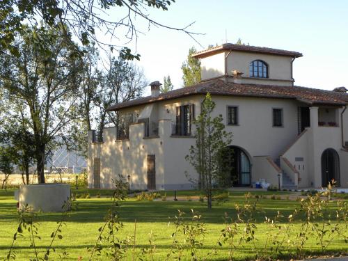 a large white house on a grass field at Il Casale di David in Pontedera