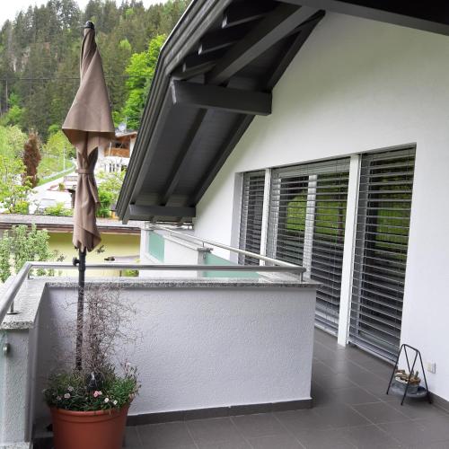 a balcony with an umbrella on a house at Appartement Au in Oberperfuss