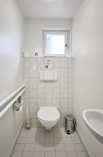 ein weißes Bad mit einem WC und einem Waschbecken in der Unterkunft Simple by Hotel du Commerce in Basel