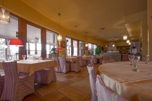 a restaurant with tables and chairs in a room at Hotel SLUNEČNÁ LOUKA in Lipno nad Vltavou