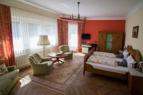 a living room with red walls and a couch and chairs at Kurvilla am Park in Bad Kissingen