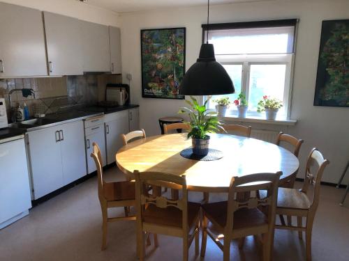 a kitchen with a dining room table and chairs at Håverud Hostel in Håverud
