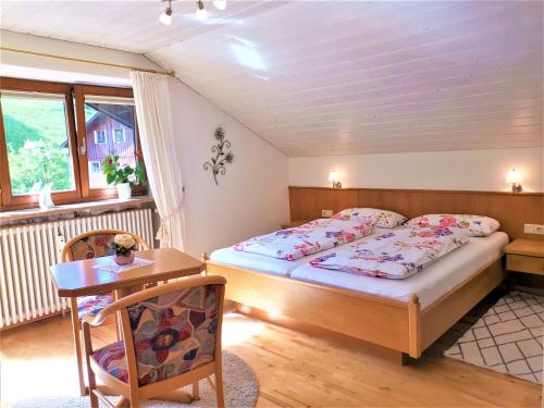 sypialnia z łóżkiem, stołem i biurkiem w obiekcie Ferienwohnung Edelweiß w mieście Bolsterlang
