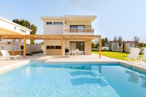 a swimming pool in front of a house at White Nest Villas in Litochoro