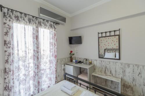 um quarto com uma cama, um lavatório e um espelho em Pegasus Rooms em Corinto