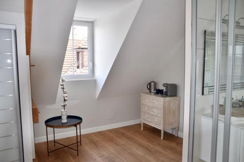 Cette chambre blanche dispose d'une chaise et d'une fenêtre. dans l'établissement Les Rougemonts Coton, à Champguyon