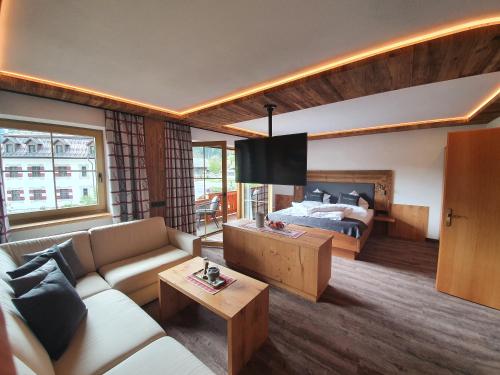 een woonkamer met een bank en een bed bij Apart Haus Alpenhof in Lermoos