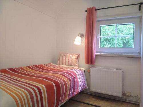a small bedroom with a bed and a window at A l'Orée du Bois in Hamoir