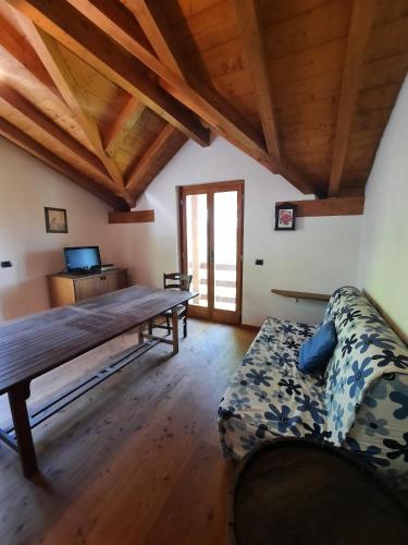 ein Wohnzimmer mit einem Sofa und einem Holztisch in der Unterkunft Chalet Grigna - Your Mountain Holiday in Esino Lario