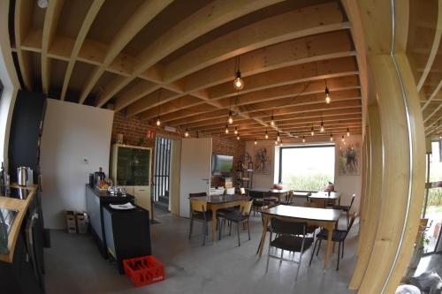 une salle à manger avec des plafonds en bois, des tables et des chaises dans l'établissement Akrenbos 101, à Bever
