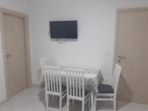 een eettafel met stoelen en een tv aan de muur bij Spirit in Međugorje