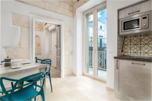 a kitchen with a table and chairs in a room at Le Bianche Suites Ostuni in Ostuni