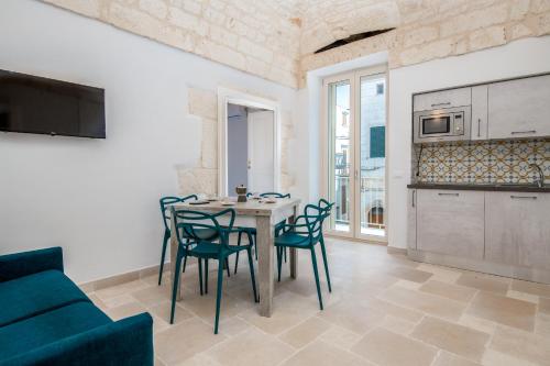 a kitchen and dining room with a table and chairs at Le Bianche Suites Ostuni in Ostuni