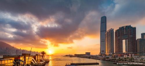 a sunset over a city with a river and buildings at The Royal Pacific Hotel & Towers in Hong Kong