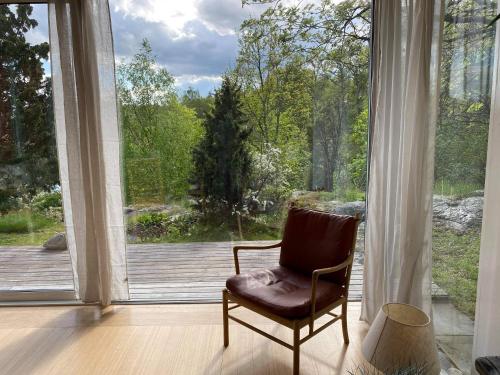 a chair sitting in front of a large window at Villa Myttinge in Värmdö