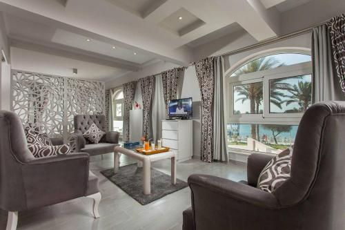 a living room with two chairs and a television at Sea Gull Marina Hotel in El Alamein
