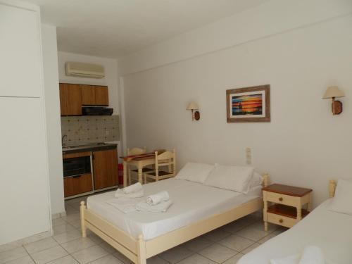 a small bedroom with a bed and a kitchen at Aeolos Hotel Apartments in Gythio