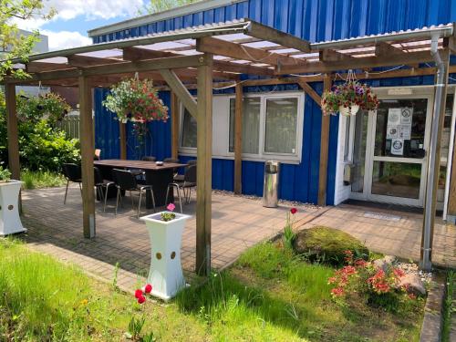 a patio with a table and a blue building at FischersPension in Ahrensburg