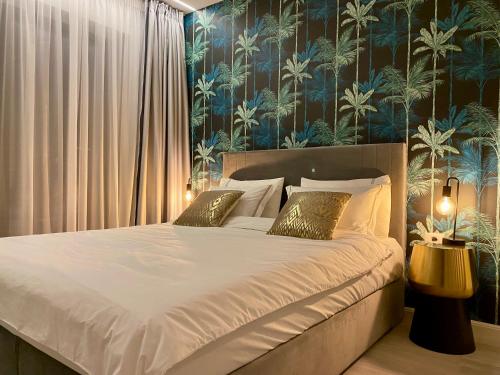 ein Schlafzimmer mit einem Bett mit einer blauen und grünen Tapete in der Unterkunft Golden Vibes in Bel Air in Mamaia