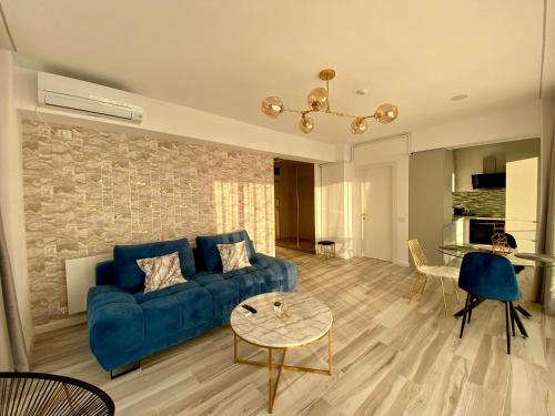 ein Wohnzimmer mit einem blauen Sofa und einem Tisch in der Unterkunft Golden Vibes in Bel Air in Mamaia