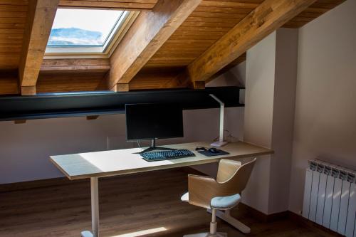 an attic office with a desk with a computer on it at La Casa del Abuelo in Hoyos del Espino