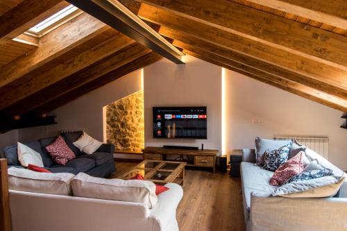a living room with two couches and a tv at La Casa del Abuelo in Hoyos del Espino