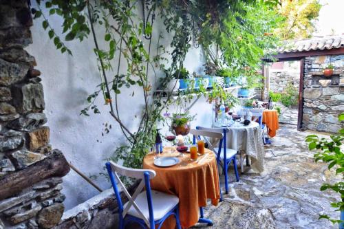 eine Terrasse mit Tischen und Stühlen im Garten in der Unterkunft Sirincem Pension in Selçuk