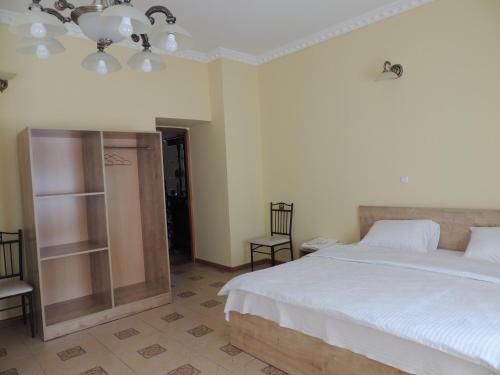a bedroom with a large white bed and two chairs at Popock City Center in Yerevan