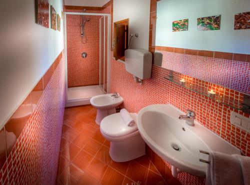 un bagno con un lavandino, un water e un lavandino di Favolosa Casa Vacanza a Cefalù a Cefalù