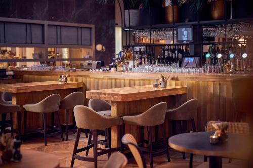 a bar with wooden tables and chairs in a restaurant at The Market Hotel in Groningen