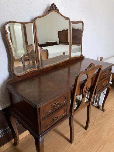 a wooden table topped with a mirror and a dresser at Hospedaria Boavista in Porto