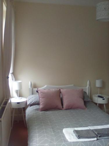 um quarto com uma cama com almofadas cor-de-rosa em 2 Bodwen Villas em Llangollen