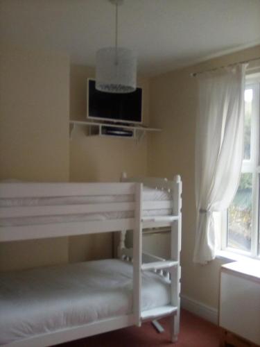 um quarto com uma cama branca e uma janela em 2 Bodwen Villas em Llangollen